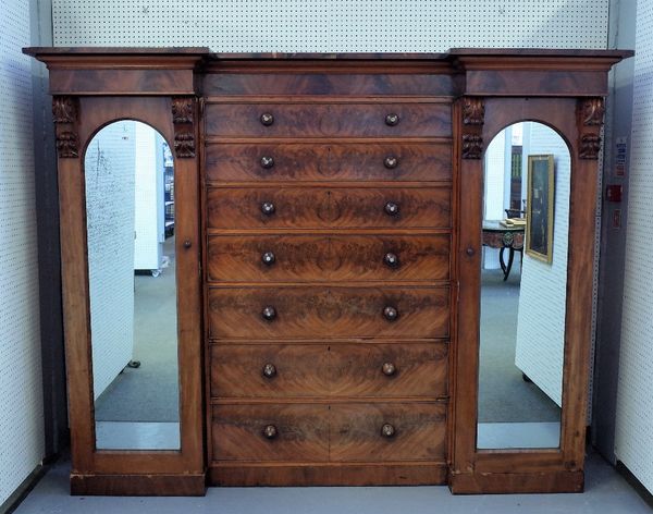 A Victorian mahogany sentry wardrobe with seven long graduated central drawers flanked by hanging cupboards, 265cm wide x 203cm high.