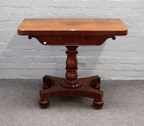 An early 19th century mahogany tea table, the foldover rectangular top on turned column and quatrefoil platform, 92cm wide x 75cm high.
