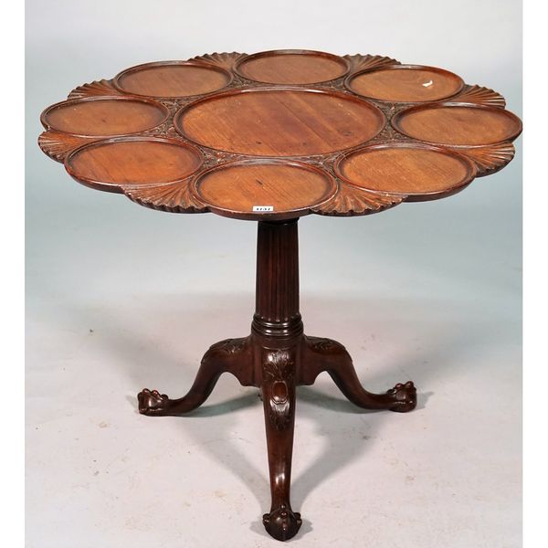 An 18th century mahogany supper table, the snap top with nine dished recess divided by scallops, the tripod base with reeded column and ball and claw