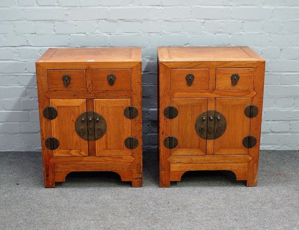 A pair of 19th century Chinese elm bedside cabinets, each with pair of drawers over cupboards, on bracket feet, 52cm wide x 69cm high.