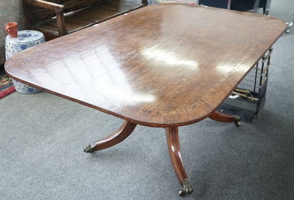 A Regency rosewood banded mahogany breakfast table, the rounded rectangular snap top on pair of turned columns an four downswept supports, 160cm wide