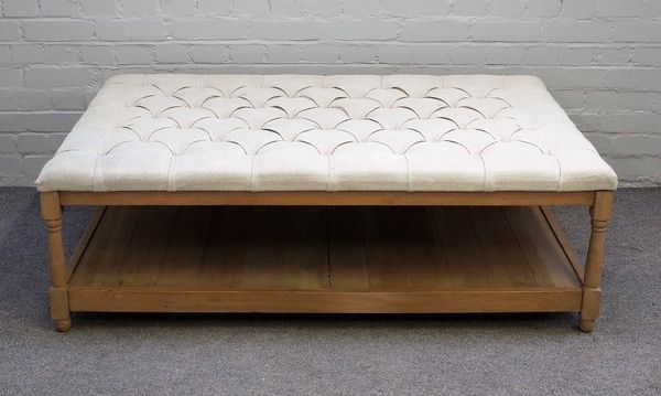 A large modern footstool coffee table, the button upholstered rectangular top on turned oak supports united by platform undertier, 138cm wide x 45cm h