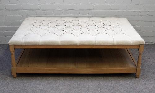 A large modern footstool coffee table, the button upholstered rectangular top on turned oak supports united by platform undertier, 138cm wide x 45cm h