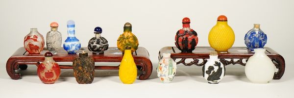 A group of fourteen Chinese snuff bottles, 20th century, including eight glass overlay examples, two yellow glass bottles, an erotic subject porcelain