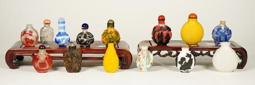 A group of fourteen Chinese snuff bottles, 20th century, including eight glass overlay examples, two yellow glass bottles, an erotic subject porcelain
