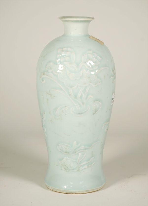 A Chinese blue glazed porcelain slender baluster vase, probably 19th century, carved in low relief with ducks, fish and a crane amongst flowering lotu