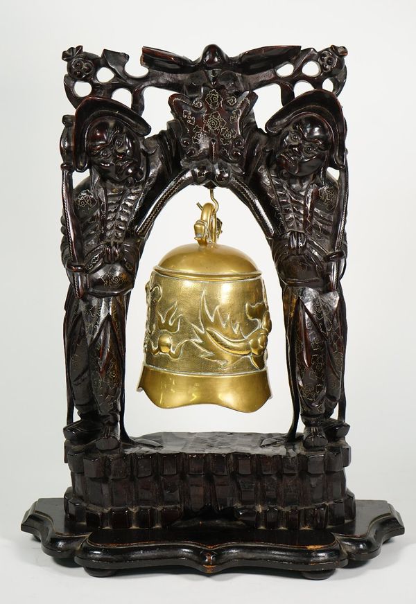 A Chinese bronze bell, early 20th century, cast with a dragon chasing a flaming pearl, housed in an inlaid hardwood frame carved with two standing fig