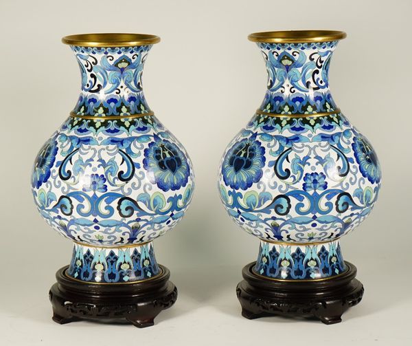 A pair of Chinese cloisonné pear shaped vases, each worked in tones of blue and green with lotus and tendrils against a white ground, 32cm high, wood