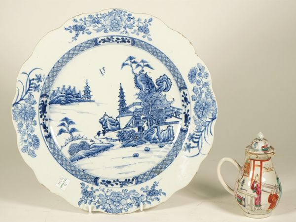 A Chinese blue and white export dish, Qianlong, painted with two figures in a river landscape, the border with four flower sprays inside a wavy rim, 3