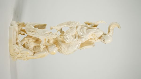 A Japanese ivory okimono of two arhats and a dragon, Meiji/Taisho period, signed, 25cm. high.