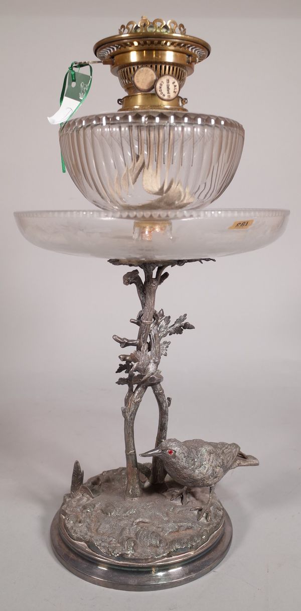 An early 20th century silver plated and glass oil lamp, with naturalistic base with mounted starling, 52cm high.   ROST