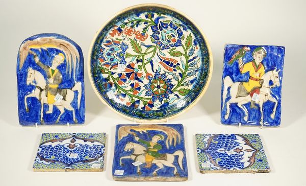 Three Qajar pottery rectangular tiles, late 19th/early 20th century, each moulded and painted with an equestrian figure with a bird, largest 23cm. by