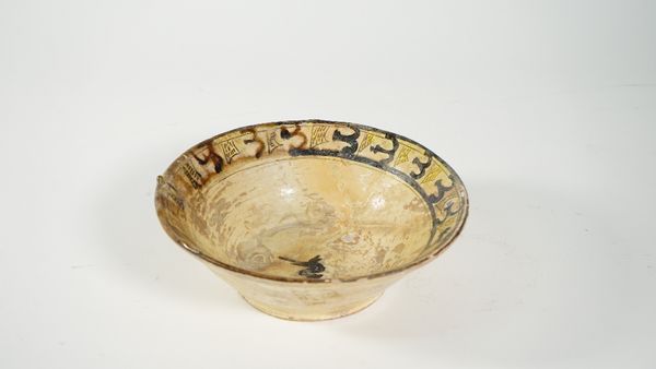 A Nishapur pottery bowl, North Eastern Iran, 12th century, painted on the interior with a border containing manganese abstract motifs, a bird in the c