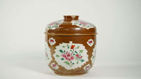 A Chinese Batavian ware famille-rose deep bowl and cover, Qianlong, painted with leaf shaped panels enclosing flowers and fruit against a cafe-au-lait