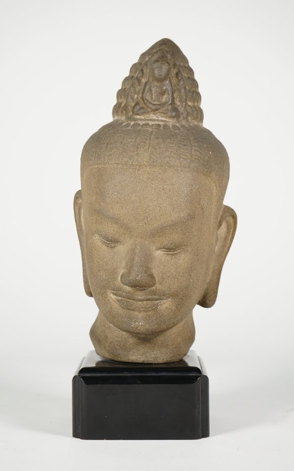 A Bayon style composition head of Buddha, 25cm. high, wood base.