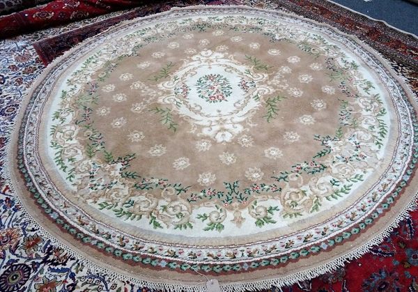 An Indian circular rug, the fawn field with floral ivory centre, floral border, 280cm diameter.  C5