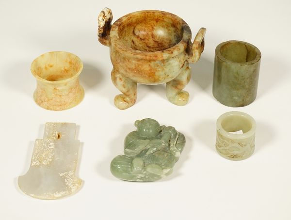 A group of Chinese jades, various colours, comprising; an archaistic axe pendant, 9cm. high; a small tripod censer, 8cm. high; a carving of a seated m