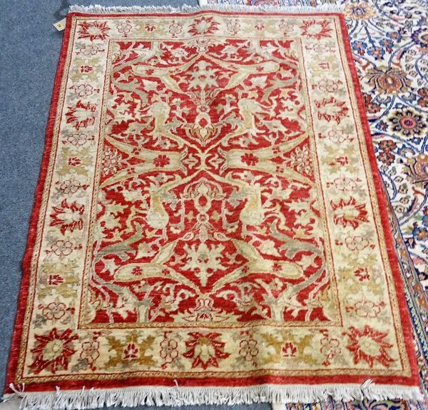 A Turkish rug, the madder field with lily-head and floral vine design, cream palmette border, 160cm x 118cm.  C3