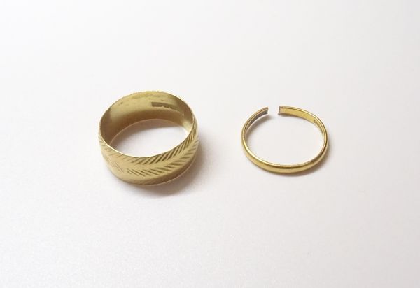 A 22ct gold wide band wedding ring, with faceted decoration, London 1969, ring size T and a 22ct gold plain wedding ring (cut), Birmingham 1939, combi