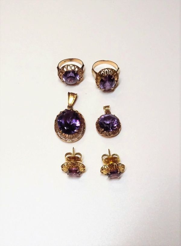 A group of synthetic corundum imitating alexandrite set jewellery, comprising; an oval solitaire pendant, detailed 14 C, a circular solitaire pendant,