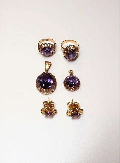 A group of synthetic corundum imitating alexandrite set jewellery, comprising; an oval solitaire pendant, detailed 14 C, a circular solitaire pendant,