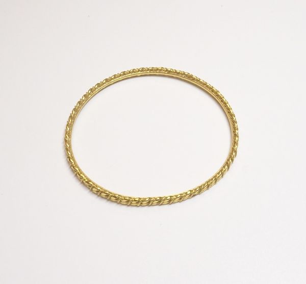 A Middle Eastern gold bangle of circular form, with faceted and ropetwist decoration, weight 16.8 gms.