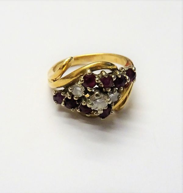 A gold, diamond and ruby ring, claw set with the principal circular cut diamond to the centre, between two smaller circular cut diamonds and otherwise