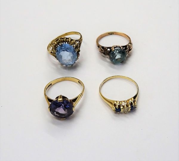 A gold, diamond and pale blue gem set three stone ring and three further gold and varicoloured gem set solitaire rings, combined gross weight 10.5 gms