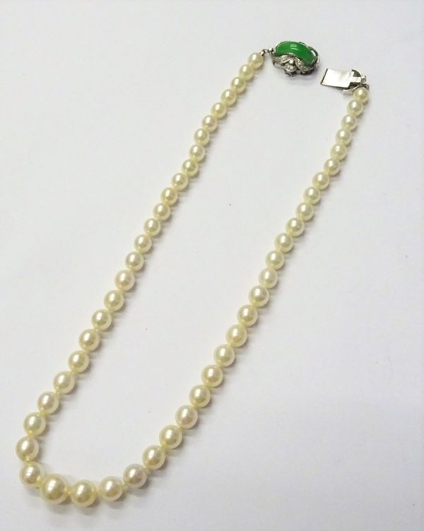 A single row necklace of graduated cultured pearls, on a white gold, jade and diamond set clasp, detailed 18 K, length  including clasp 39cm.