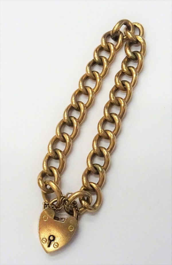 A gold hollow curb link bracelet, detailed 9 C, on a gold heart shaped padlock clasp, detailed 9 CT, fitted with a safety chain, gross weight 14.7 gms