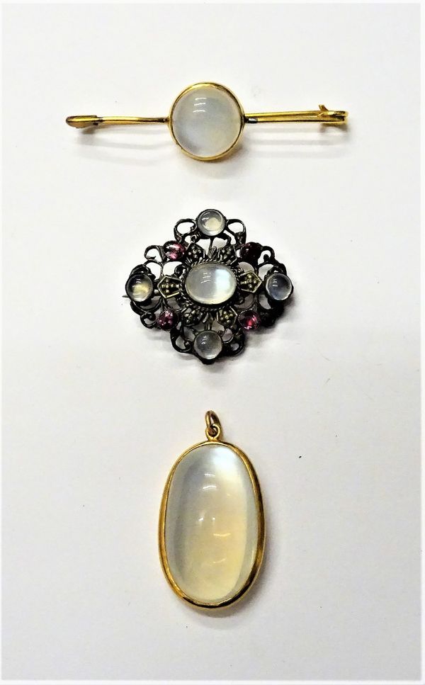 A moonstone single stone pendant, a moonstone single stone bar brooch and a moonstone and garnet set brooch, with scroll pierced decoration, (3).