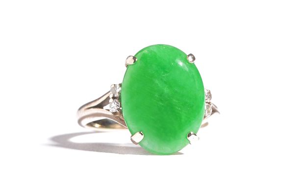 A jade and diamond ring, claw set with the oval jade between circular cut diamond set two stone split shoulders, ring size K.