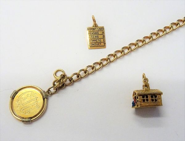 A gold curb link bracelet detailed 14 KT, on a boltring clasp, with a gold pendant medallion, detailed 14 K and two gold charms, comprising; a cottage