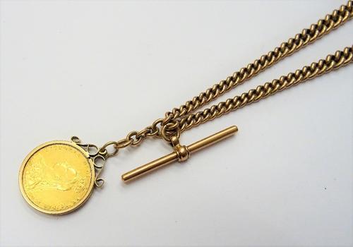 A gentleman's 9ct gold graduated curb link watch Albert chain, fitted with a 9ct gold T bar and with two 9ct gold swivels, also a gold mounted Victori