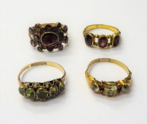An early 19th century gold ring, mounted with foil backed flat cut garnets, between split shoulders, a Victorian gold, chrysolite and red gem set ring