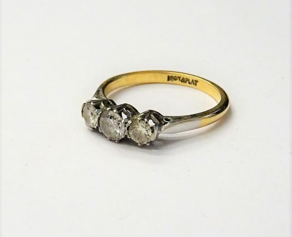 A gold and platinum, diamond set three stone ring, claw set with a row of circular cut diamonds, detailed 18 CT & PLAT, ring size K and a half, gross