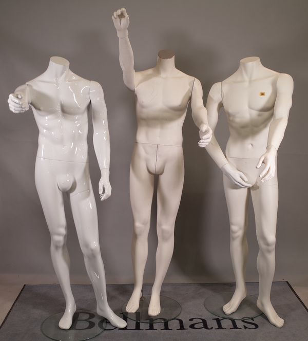 A group of three modern white adult male shop mannequins. A1