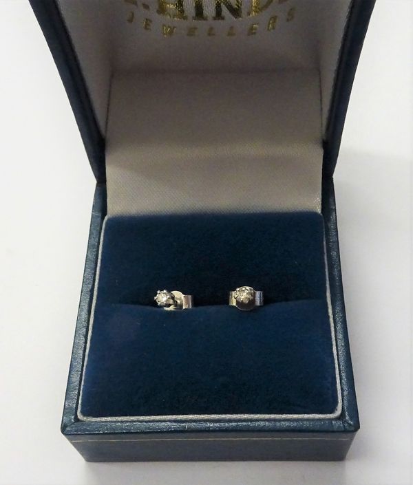 A pair of diamond set single stone earstuds, each claw set with a circular cut diamond, the backs with silver post and butterfly clip fittings, with a