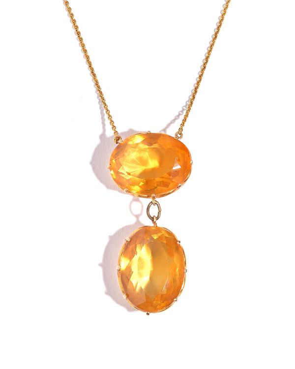 A gold and citrine two stone pendant necklace, claw set with two oval cut citrines, connected by a base metal link, on a gold neckchain, with a snap c