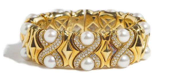 An Italian gold, diamond set and cultured pearl sprung bangle, the front designed as curved 'X' shaped links set with circular cut diamonds to the thr