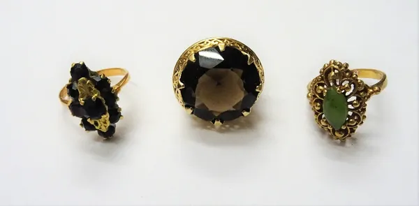 A gold ring, claw set with a circular cut smoky quartz, detailed 14 K and two further gold and gem set rings, (3).