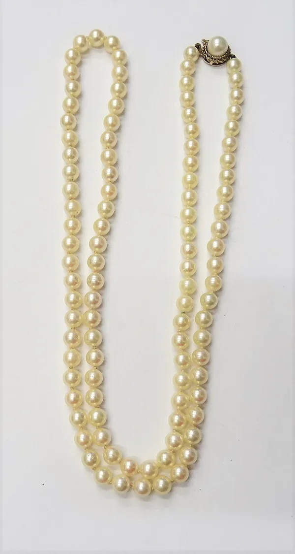 A single row necklace of uniform cultured pearls, on a 9ct gold and cultured pearl set clasp, length excluding clasp 65cm.