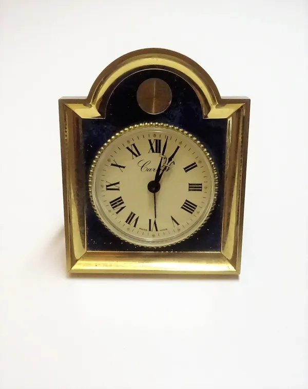 A Swiss gilt metal and simulated lapis lazuli keyless wind alarm clock, the circular cream coloured dial with black Roman numerals and detailed Cartie