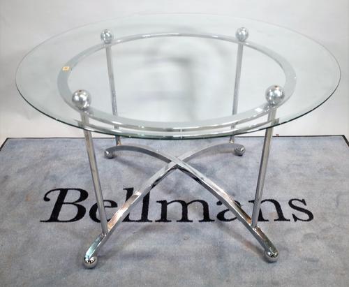 A 20th century glass circular dining table on chrome base, united by 'X' frame stretcher, 89cm diameter x 77cm high.   C5