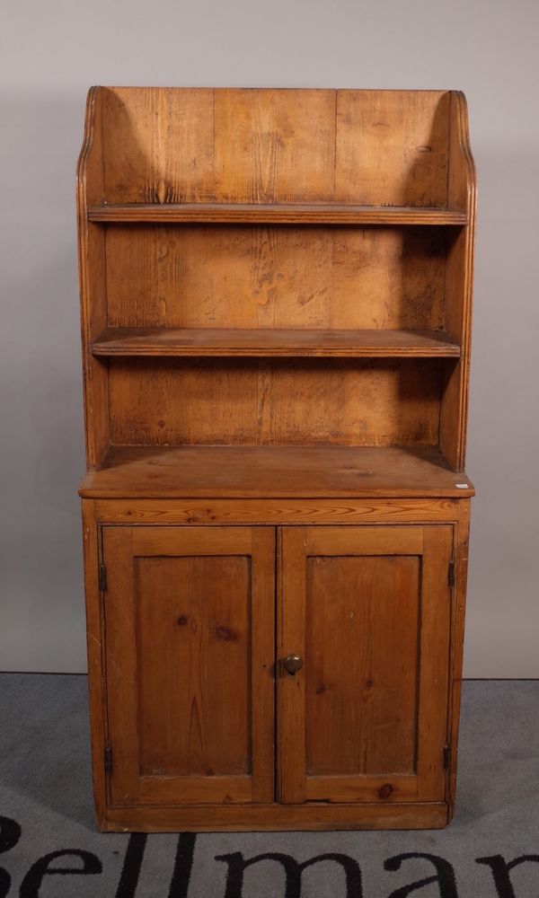 A small 19th century pine bookcase cupboard, the enclosed three tier plate rack over a pair of cupboards, 64cm wide x 128cm high. A1