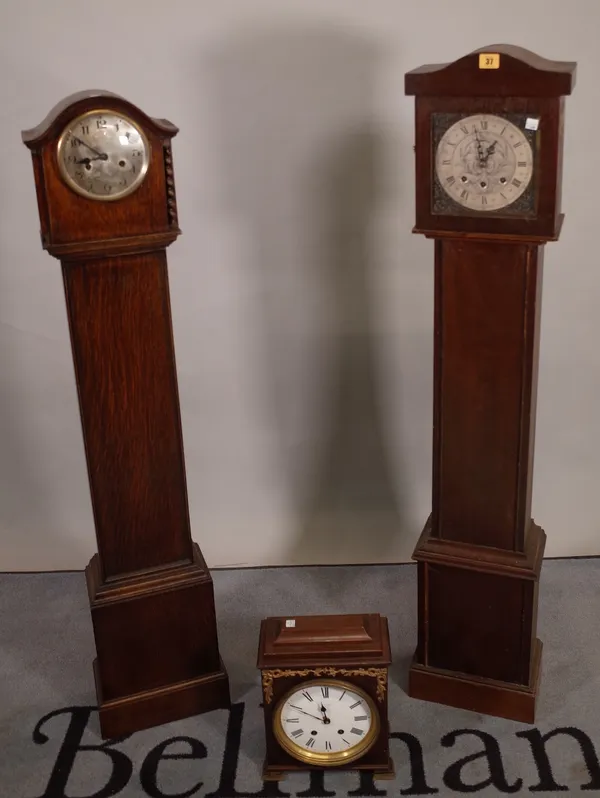 An early 20th century 8 day oak longcase clock, 27cm wide x 135cm high and another similar, 26cm wide x 130cm high and a mahogany clock, 20cm wide x 3