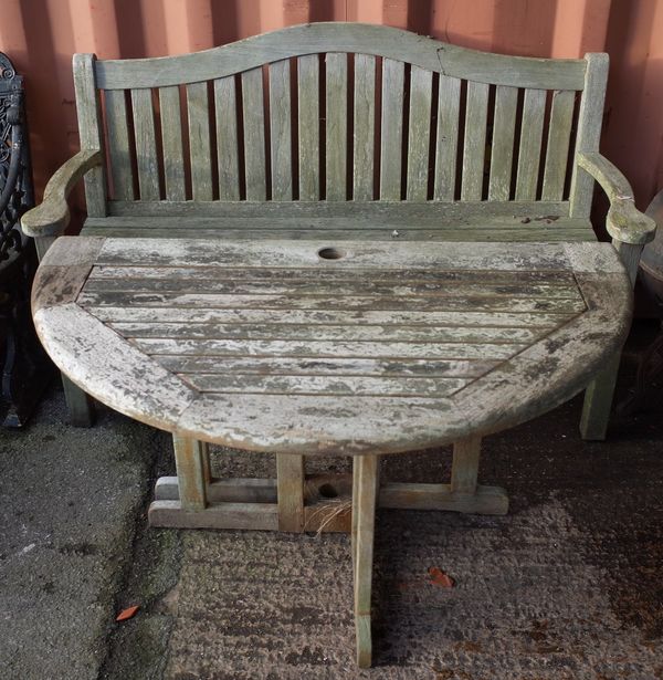 Garden furniture; a teak arched back garden bench, 154cm wide x 100cm high and a drop flap circular table, 120cm diamerte x 80cm high, (2).  OUT