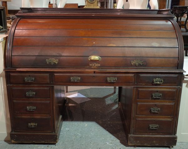 An early 20th century mahogany roll top desk with fitted interior and nine drawers about the knee, 152cm wide x 122cm high.  B3