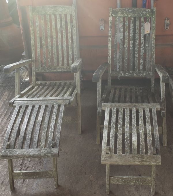 A pair of 20th century garden steamer chairs, 59cm wide x 128cm high, two footstools 54cm wide x 32cm high and a side table 44cm wide x 38cm high.  OU