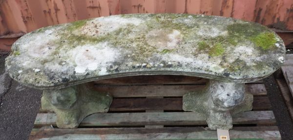 A 20th century reconstituted stone concave garden bench with carved lion mask supports, 120cm wide x 40cm high.   OUT